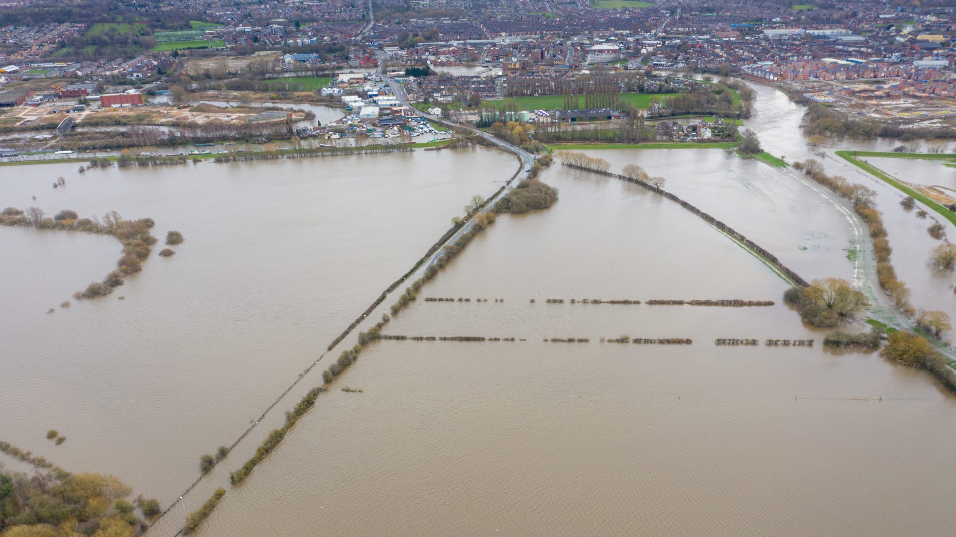 Aerial drone photo of the town of Allerton Bywater near Castleford in Leeds West Yorkshire showing the flooded fields and farm house from the River Aire during a large flood after a storm.