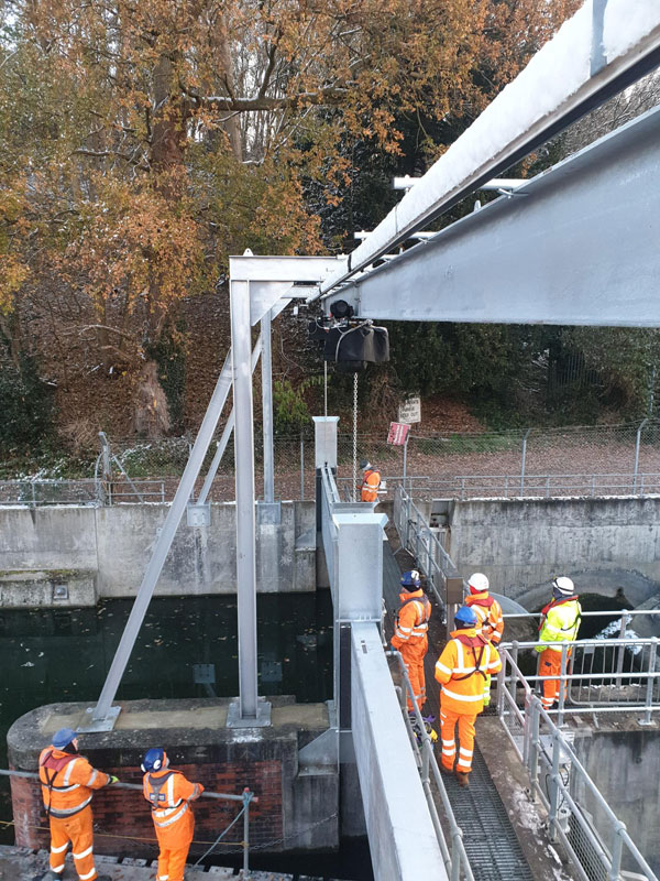 The tandem hoist side view lifting stop log with spreader beam. 