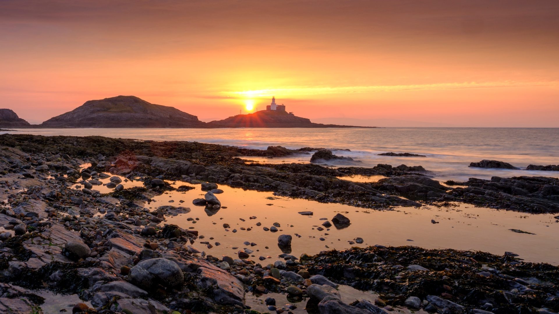 Sunrise on the Mumbles Light House from Bracelet Bay, Gower Peninsula, Wales, UK