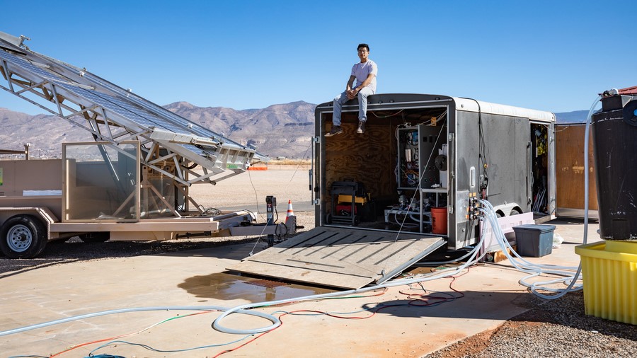 Jon Bessette sits atop a trailer housing the electrodialysis desalination system at the Brackish Groundwater National Desalination Research Facility (BGNDRF) in Alamogordo, New Mexico. The system is connected to real groundwater, water tanks, and solar panels. (c) Shane Pratt